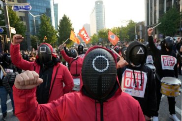 Мы тоже пытаемся заработать: десятки тысяч возмущенных корейцев вышли на улицы в костюмах из “Игры в кальмара”