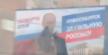 В Новосибирске коммунальщики руками моют баннеры с Путиным