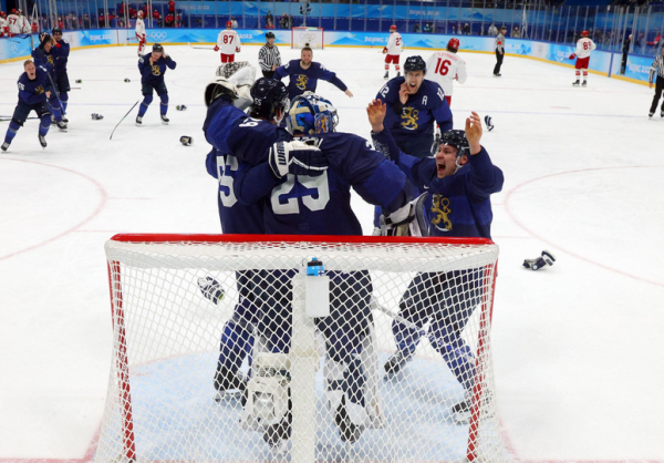 Хоккеисты Финляндии празднуют победу после финального свистка.